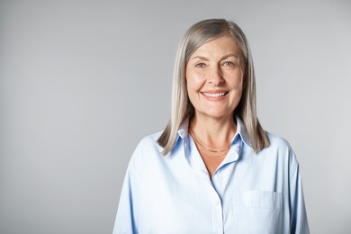 Photo of Portrait of beautiful senior woman on light background. Space for text