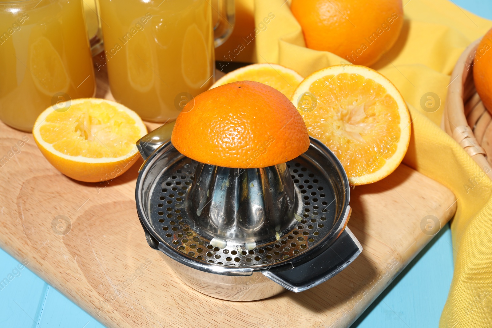 Squeezer, oranges and fresh juice on blue wooden table, closeup Photo of Squeezer, oranges and fresh juice on blue wooden table, closeup