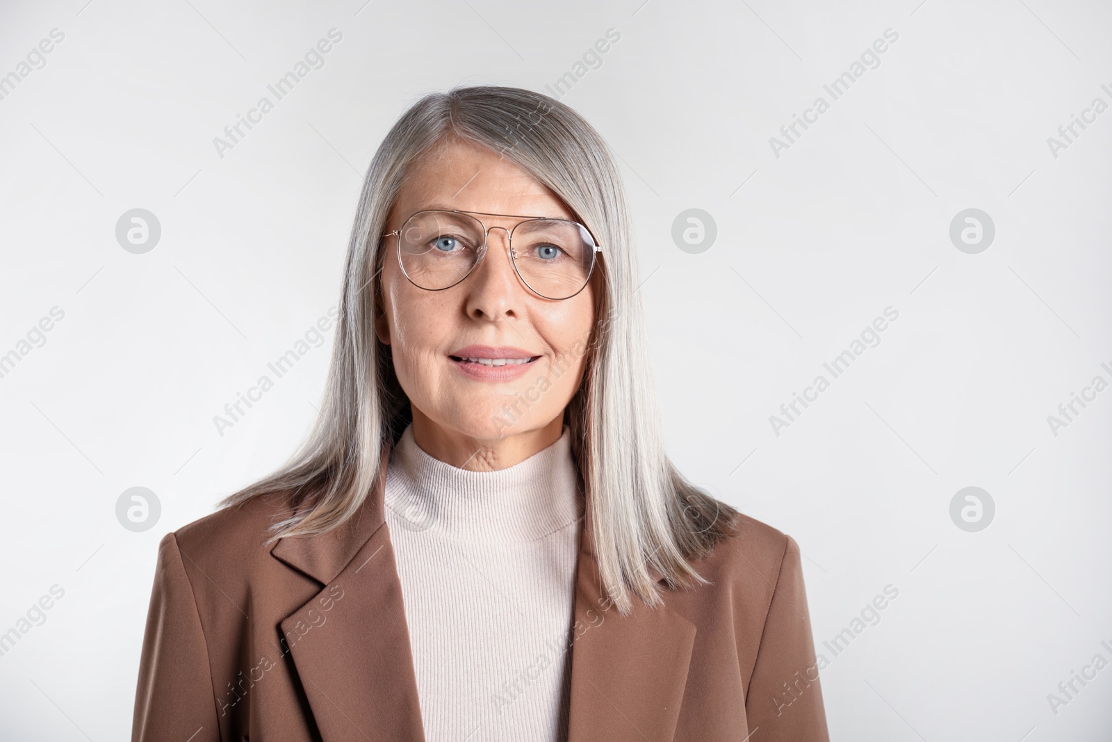 Photo of Portrait of beautiful senior woman on light background. Space for text