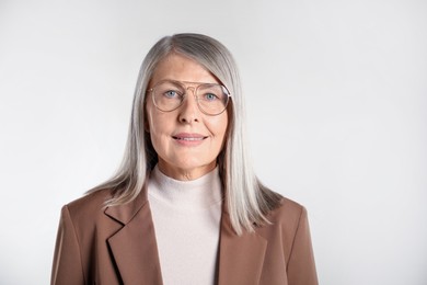 Photo of Portrait of beautiful senior woman on light background. Space for text