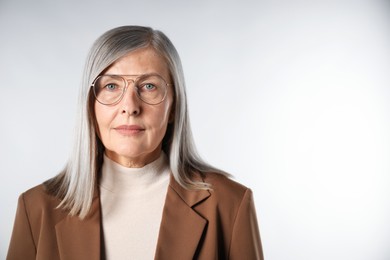 Photo of Portrait of beautiful senior woman on light background. Space for text