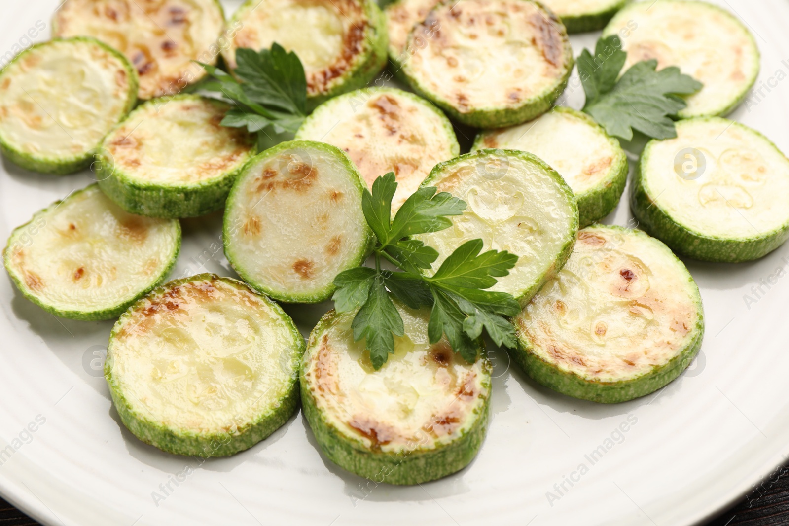 Delicious fried courgette slices with parsley on plate, closeup Photo of Delicious fried courgette slices with parsley on plate, closeup