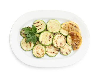Photo of Delicious grilled courgette slices with lemon and parsley isolated on white, top view
