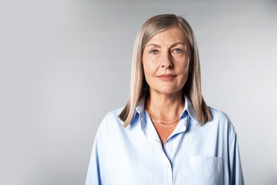 Photo of Portrait of beautiful senior woman on light background. Space for text
