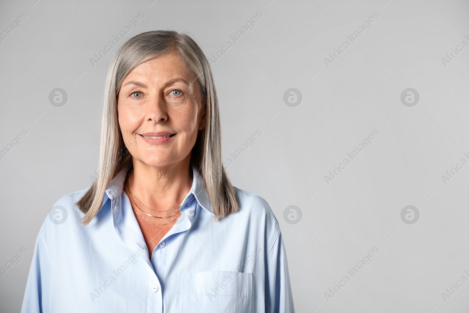Photo of Portrait of beautiful senior woman on light background. Space for text