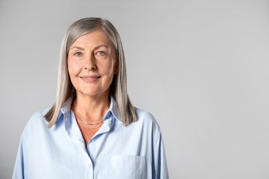 Photo of Portrait of beautiful senior woman on light background. Space for text