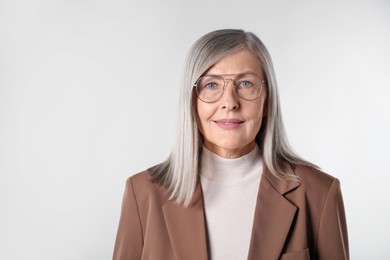 Photo of Portrait of beautiful senior woman on light background. Space for text