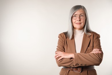 Photo of Portrait of beautiful senior woman on light background. Space for text