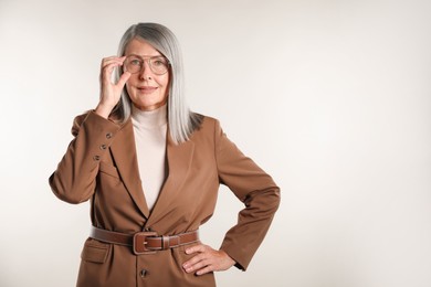 Photo of Portrait of beautiful senior woman on light background. Space for text