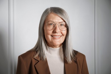 Photo of Portrait of beautiful senior woman near white wall