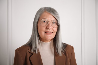 Photo of Portrait of beautiful senior woman near white wall