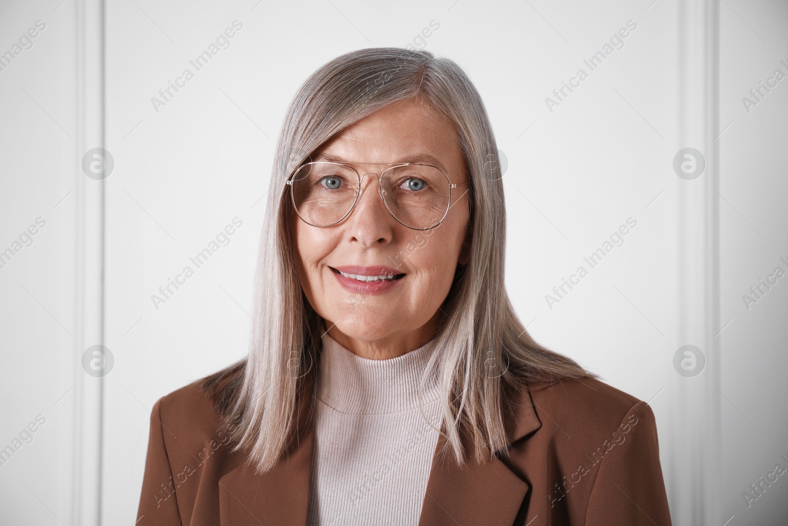 Photo of Portrait of beautiful senior woman near white wall