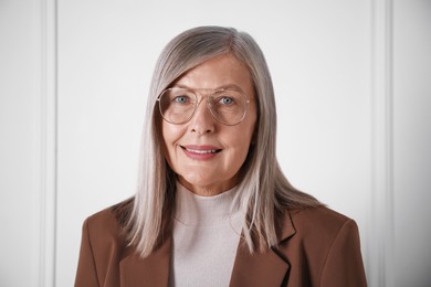 Photo of Portrait of beautiful senior woman near white wall