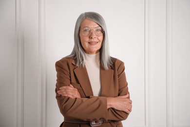 Photo of Portrait of beautiful senior woman near white wall