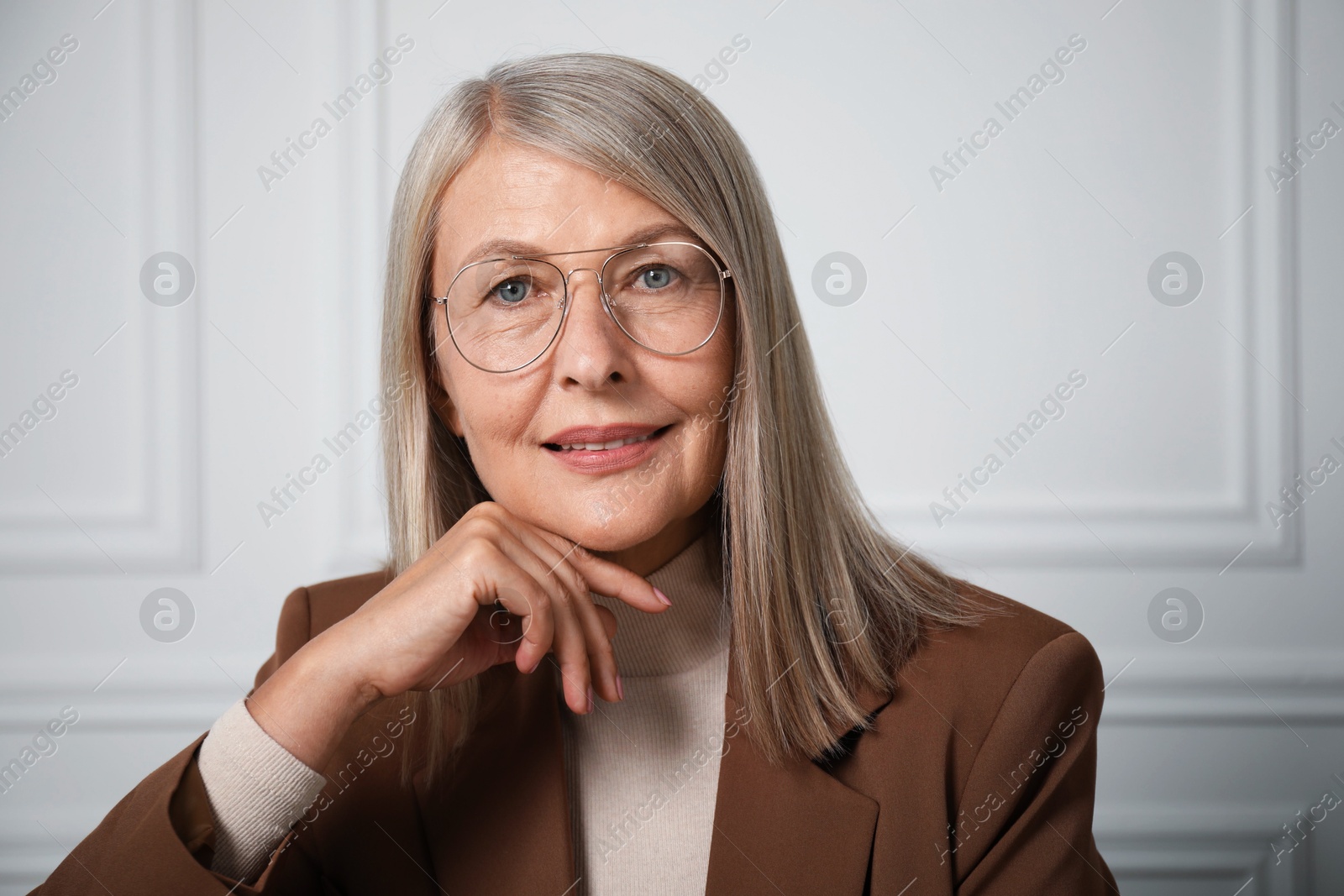 Photo of Portrait of beautiful senior woman near white wall