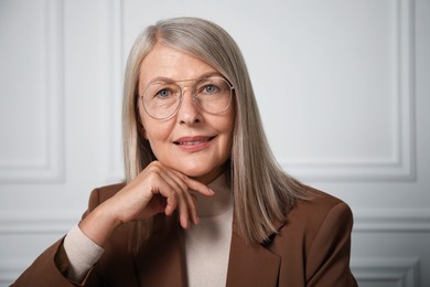 Photo of Portrait of beautiful senior woman near white wall