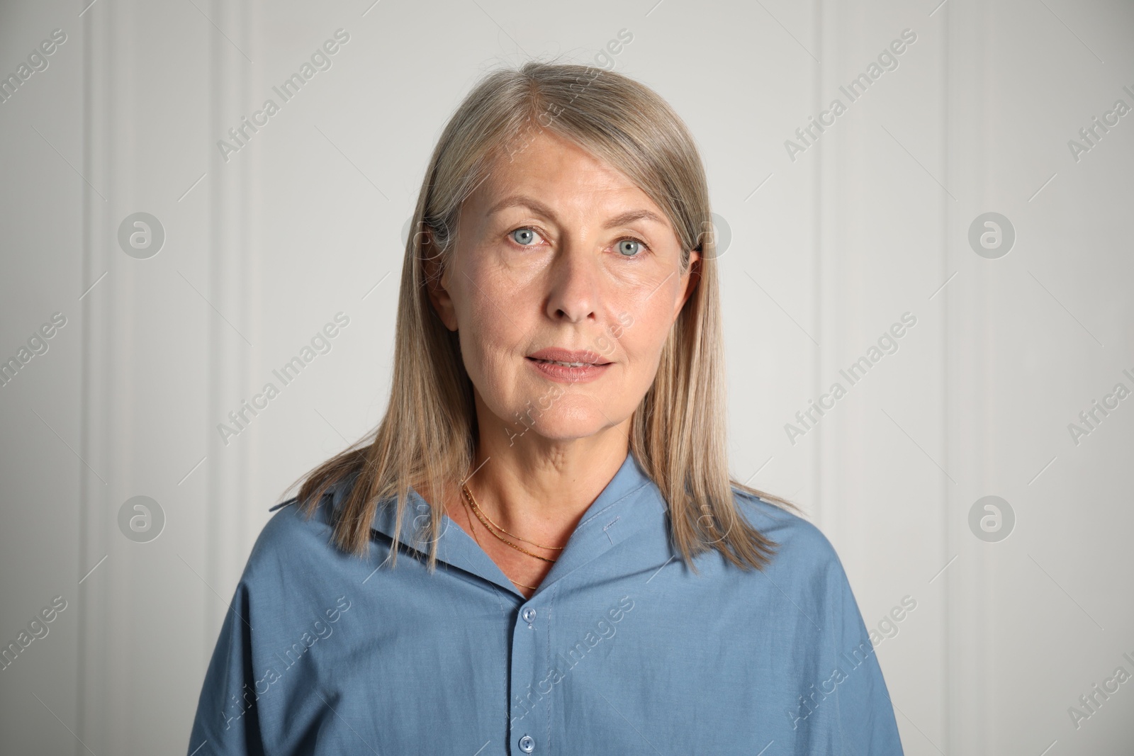 Photo of Portrait of beautiful senior woman near white wall
