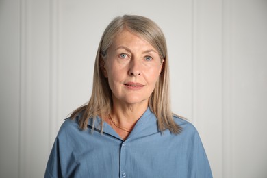Photo of Portrait of beautiful senior woman near white wall