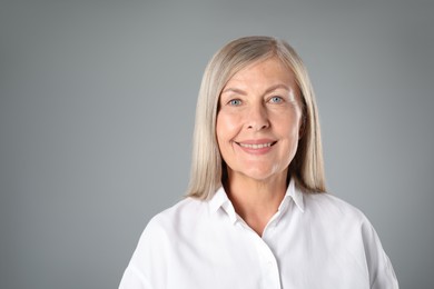 Photo of Portrait of beautiful senior woman on grey background. Space for text