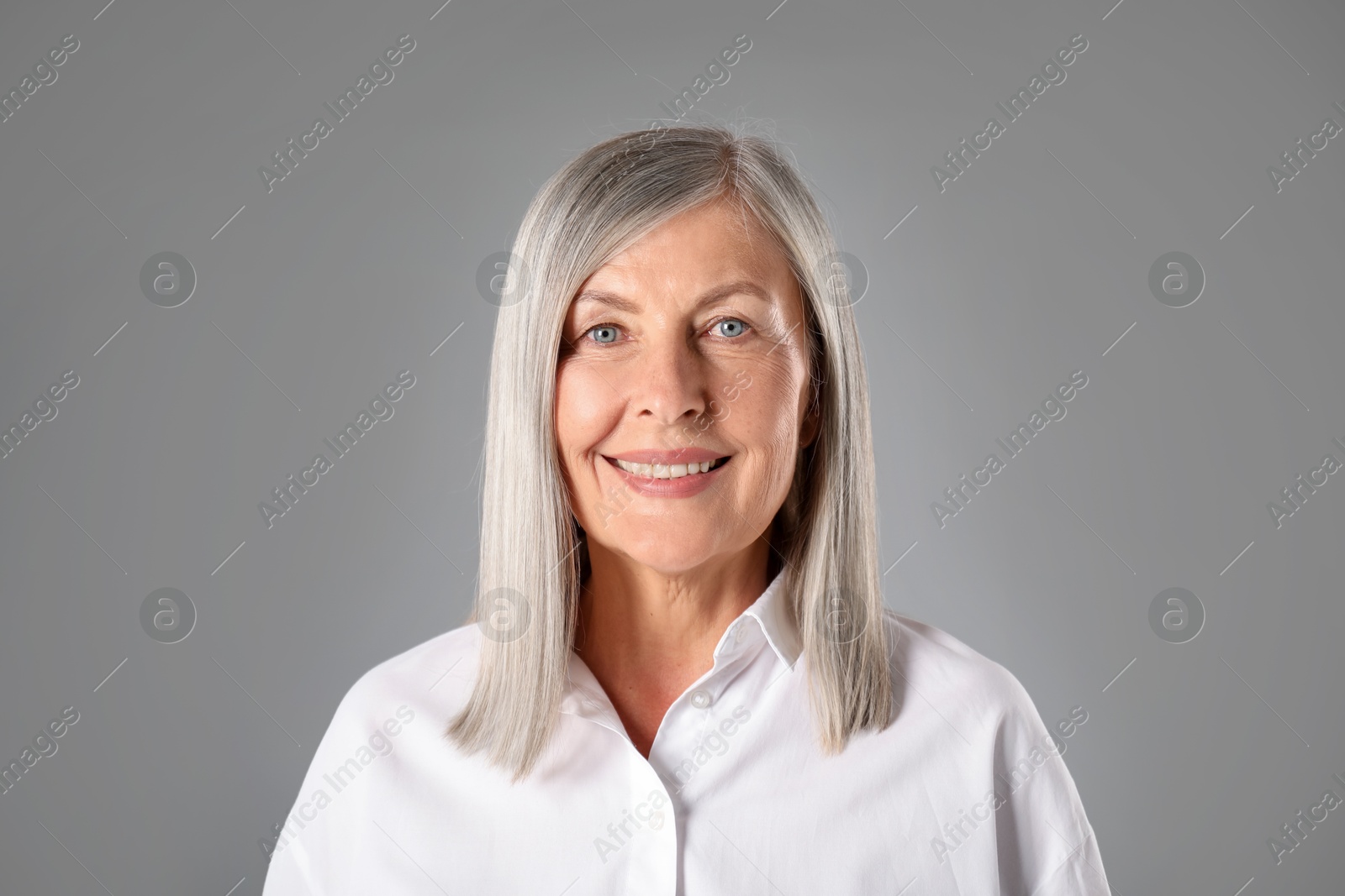 Portrait of beautiful senior woman on grey background Photo of Portrait of beautiful senior woman on grey background