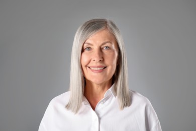 Photo of Portrait of beautiful senior woman on grey background