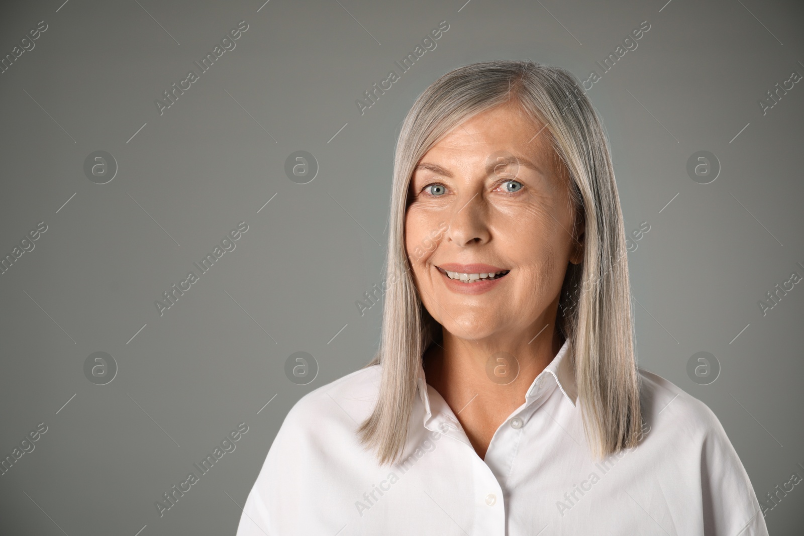 Photo of Portrait of beautiful senior woman on grey background. Space for text