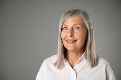 Photo of Portrait of beautiful senior woman on grey background. Space for text