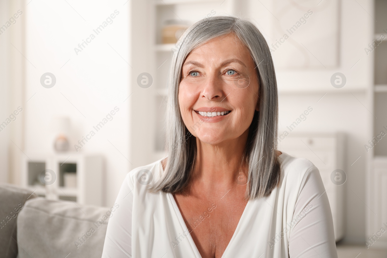 Photo of Elegant senior woman on sofa at home. Space for text