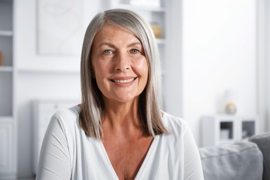 Photo of Elegant senior woman on sofa at home