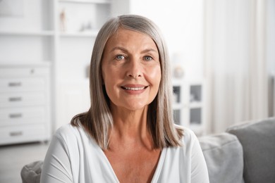 Photo of Elegant senior woman on sofa at home