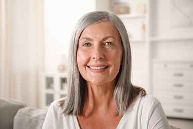 Photo of Elegant senior woman on sofa at home