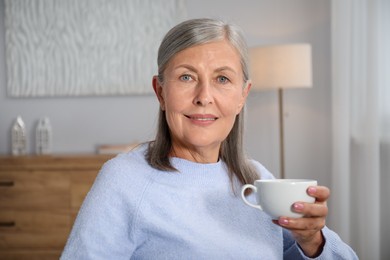 Photo of Beautiful senior woman having tea at home