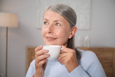 Photo of Beautiful senior woman having tea at home