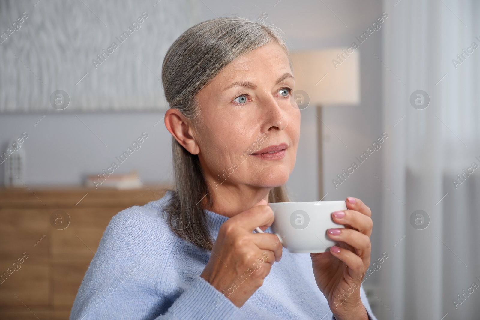 Photo of Beautiful senior woman having tea at home