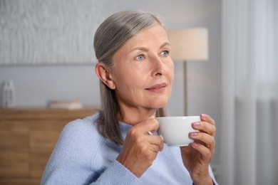 Photo of Beautiful senior woman having tea at home