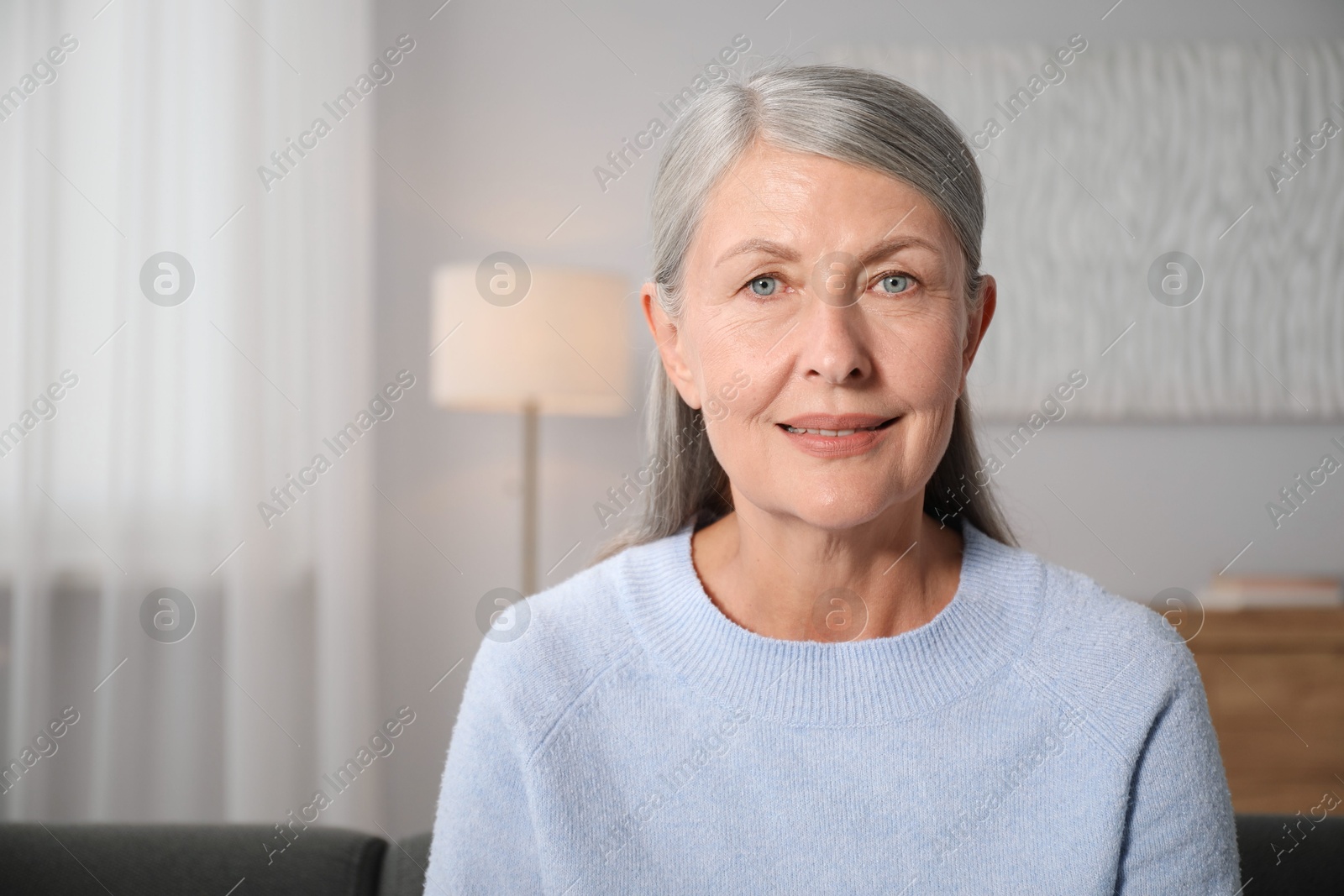 Photo of Elegant senior woman at home. Space for text
