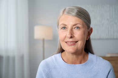 Photo of Elegant senior woman at home. Space for text