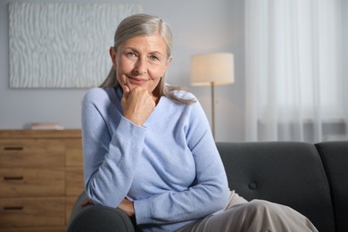 Photo of Elegant senior woman on sofa at home. Space for text
