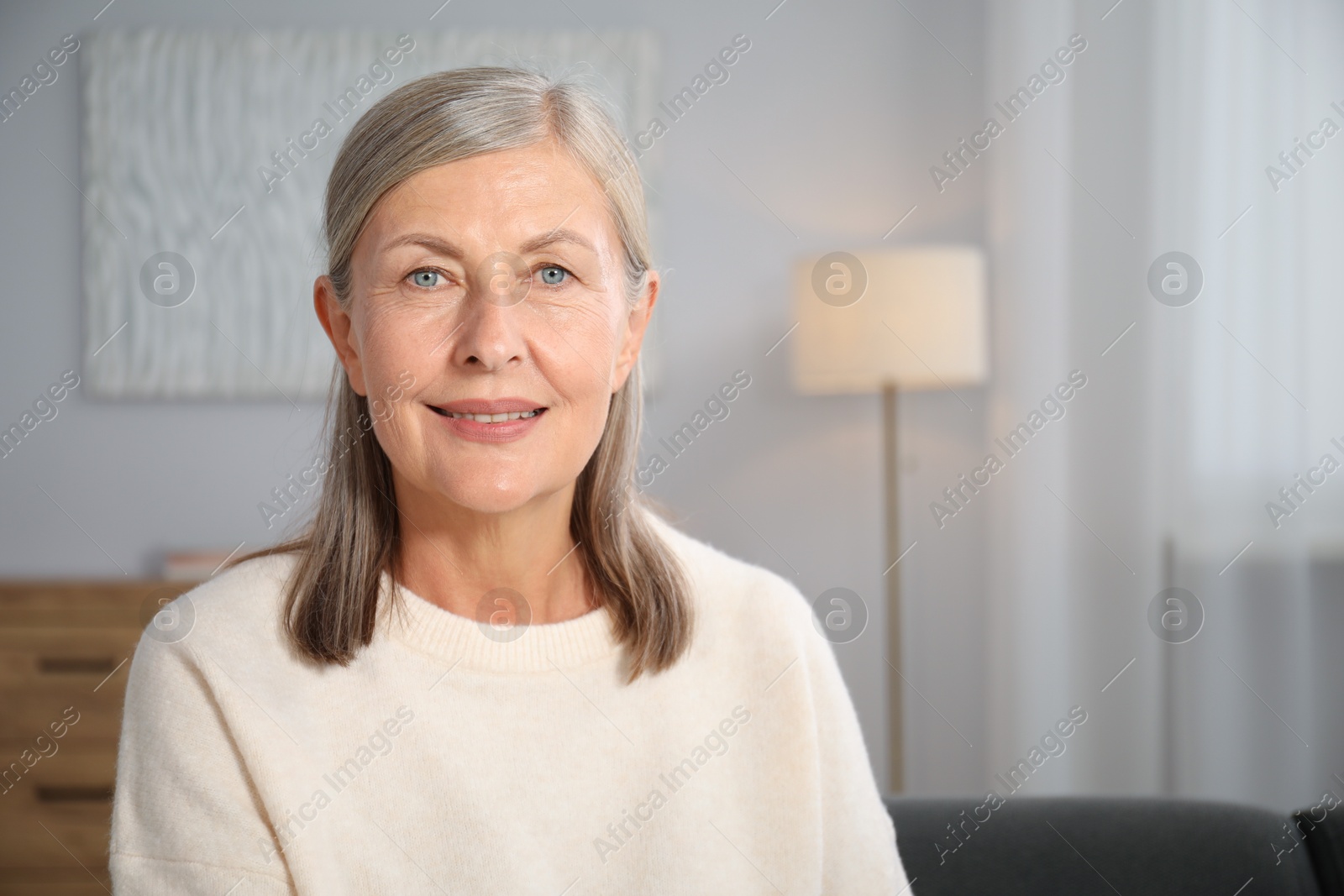 Photo of Elegant senior woman at home. Space for text