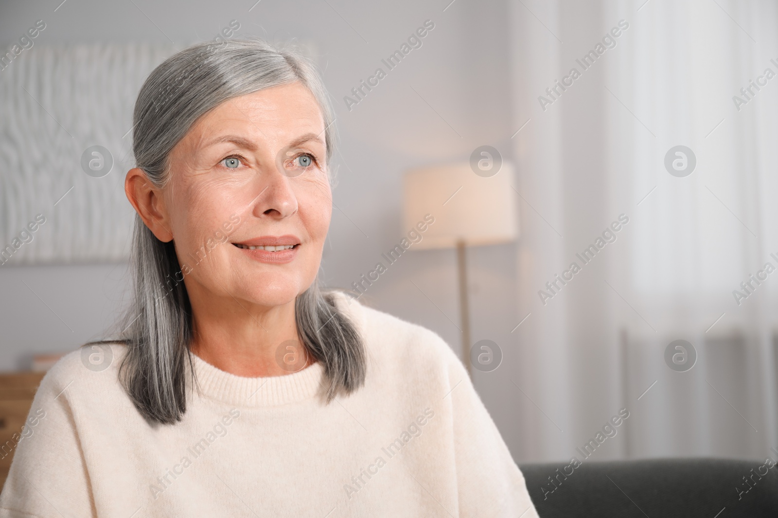Photo of Elegant senior woman at home. Space for text