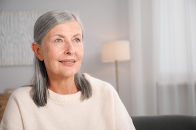 Photo of Elegant senior woman at home. Space for text