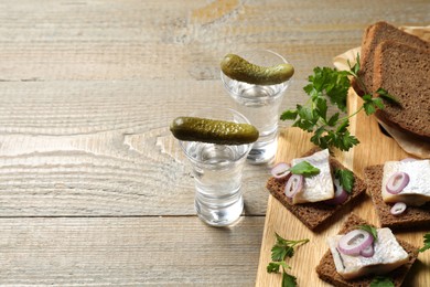 Photo of Cold Russian vodka with snacks on wooden table, above view