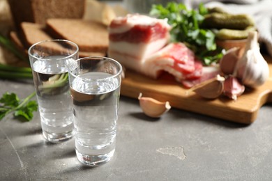 Photo of Cold Russian vodka with snacks on grey table