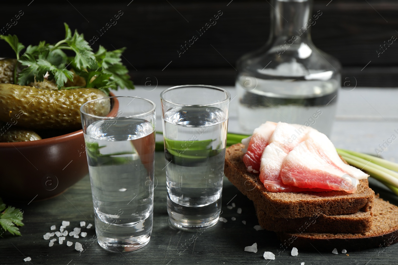 Cold Russian vodka with snacks on wooden table Photo of Cold Russian vodka with snacks on wooden table