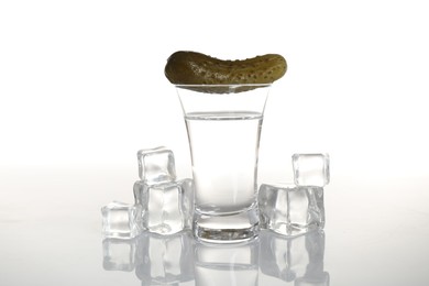 Photo of Russian vodka, pickle and ice cubes isolated on white