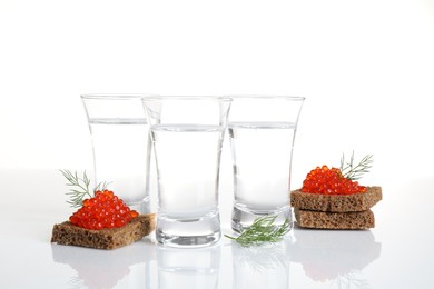 Photo of Russian vodka and red caviar sandwiches isolated on white