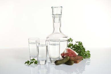 Photo of Russian vodka and different appetizers isolated on white