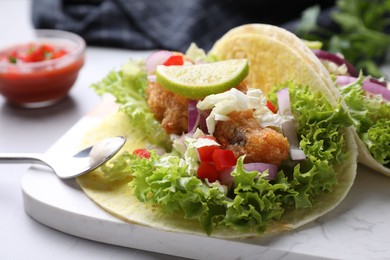 Photo of Delicious fish tacos served on light grey table, closeup