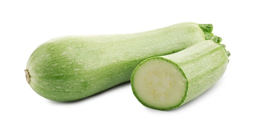 Photo of Fresh whole and cut zucchinis isolated on white