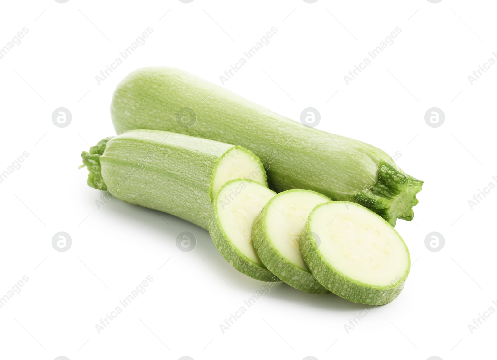 Photo of Fresh whole and cut zucchinis isolated on white